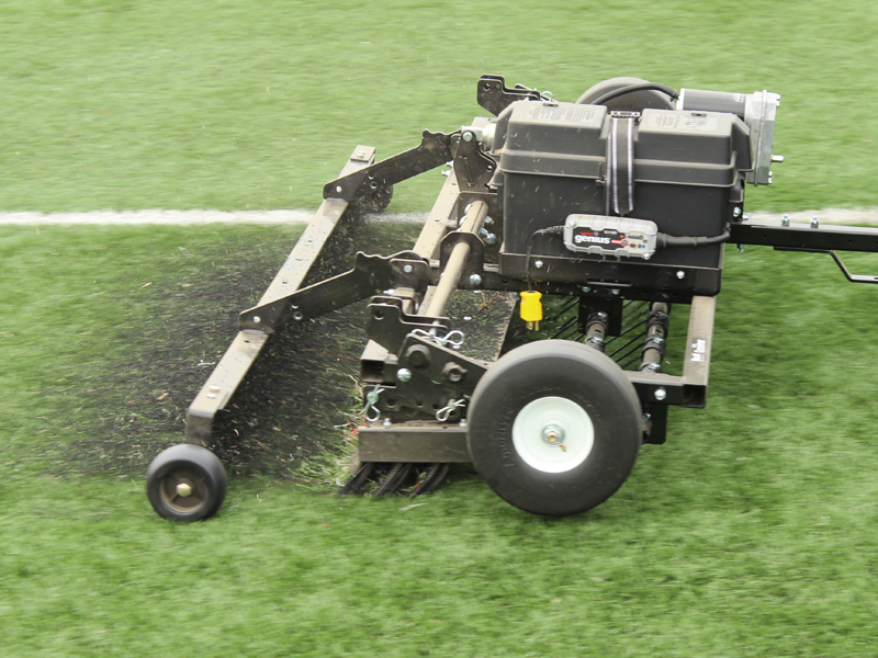 Sports turf groomer maintaining artificial turf field surface
